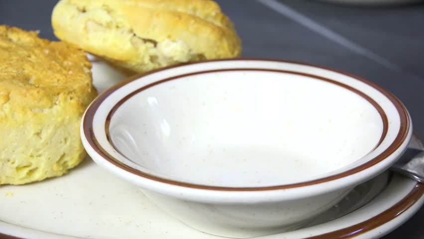 Spooning country gravy with sausage into a bowl