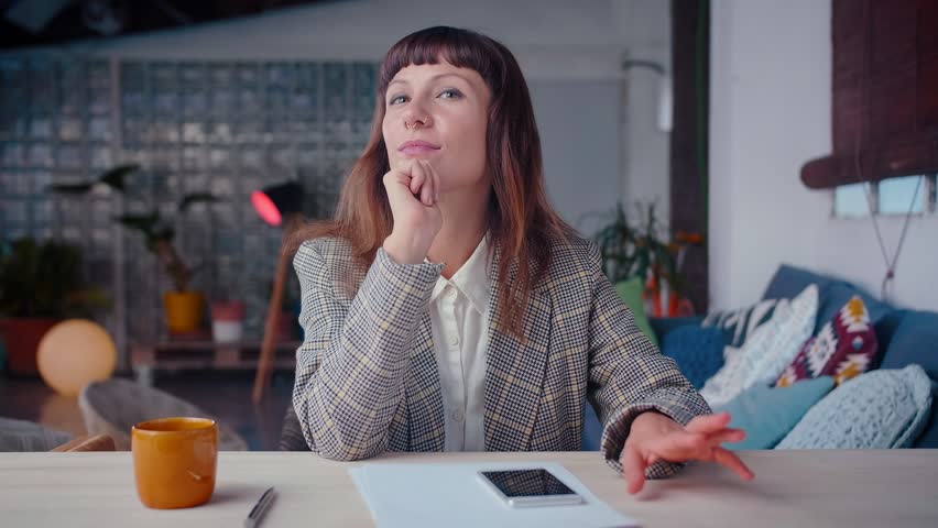 Pensive business elegant woman texting on smart phone device in office, getting genial idea, entrepreneur goals, making a gesture, hard worker, using online messenger application, ceramic cup in front