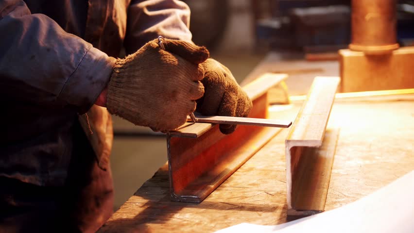 Construction plant. A worker making marks on an iron detail | Shutterstock HD Video #1026891068