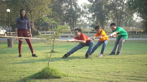 Asian students girls and boys play tug of war