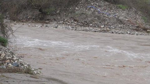 Panning shot of the Kseros river in Cyprus as it overflows causing flooding that passes from the bridge of the Ziripilis area