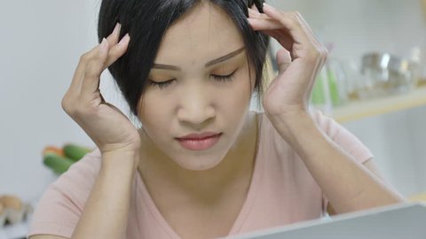 Asian woman feeling stress from work in the office.Tired business woman at workplace in office holding his head on hands feel headache.