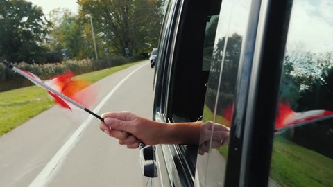 Hand with a small Canadian flag. Waving a flag from the car window Video stock