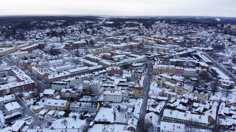 Reverse drone footage revealing the old cathedral of Strängnäs with the old town and a frozen lake in the background. Filmed in realtime at 4k.