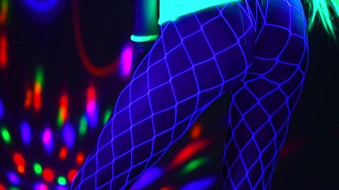 Beauty Model girl dancing in UV neon lights. Beautiful sexy young woman with perfect slim body dance in night club. Booty dance. Sexy buttocks, Seduction. Night life. Ultraviolet. Slow motion 4K UHD