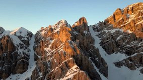 Aerial video in winter at sunset time in Dolomites, to Cristallo mountain special rocks near Cortina D'Ampezzo.