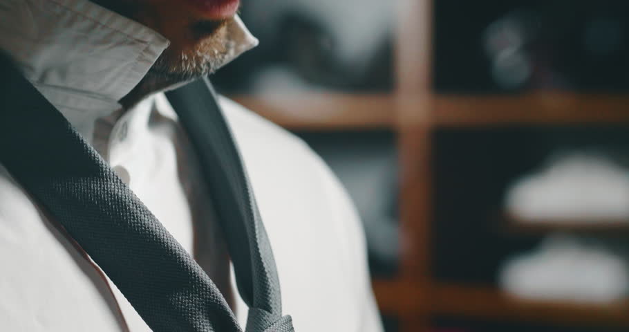 Slow motion close up of handsome businesman trying a new high quality tailor made suit and first ties a tie in atelier. Royalty-Free Stock Footage #1026909902