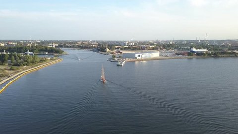 A boat floating on the Baltic Sea (Gulf of Gdansk) at the mouth of the port. Footage from the perspective of a drone.