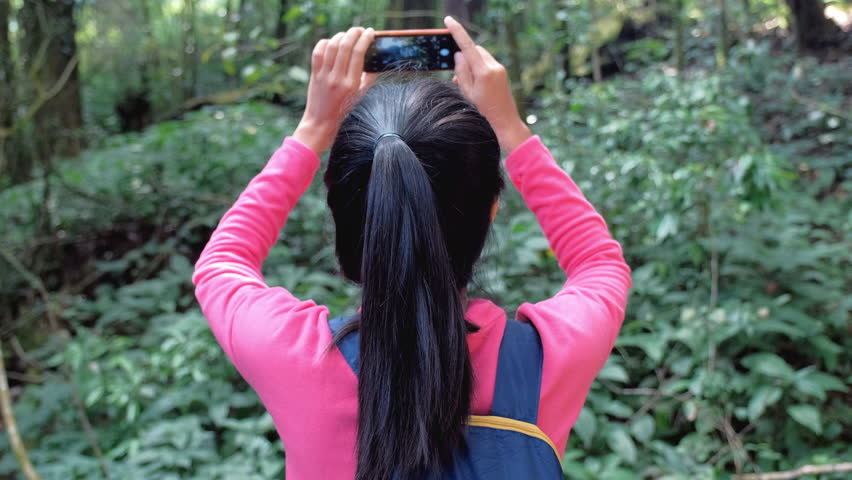 Hipster traveler with backpack taking a picture and enjoying a beautiful nature.Travel concept.Gimbal shot 