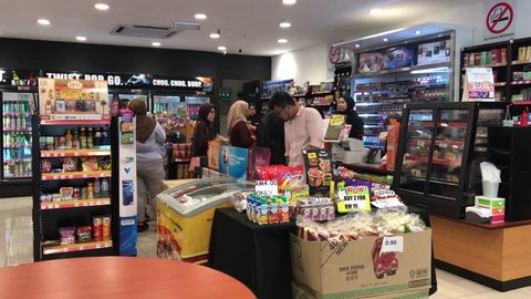 SHAH ALAM, MALAYSIA - March 29, 2019 : 4K footage, Interior view of customers at cashier counter queuing to make payment at 7-Eleven convenience store.