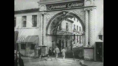 CIRCA 1945 - A young woman sneaks past a guard to get onto the Paramount backlot.