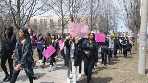 Toronto, Canada - Apr 4, 2019: Humber College students with posters participate in Ontario protest rally demonstration walk against Doug Ford provincial government's changes to the education system.