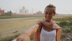 Follow me to the Taj Mahal, India. Female tourist leading boyfriend to there magnificent famous Mausoleum in Agra. People travel concept.
Girl holding boyfriends hand to travel together