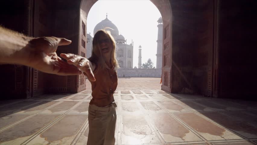 Follow me to the Taj Mahal, India. Female tourist leading boyfriend to there magnificent famous Mausoleum in Agra. People travel concept - Girl holding man hand at sunrise traveling together- Slow mo | Shutterstock HD Video #1026941087