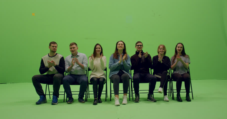 GREEN SCREEN CHROMA KEY Front view group of young people sitting, applause and looking at smth behind the camera. 4K UHD ProRes 4444