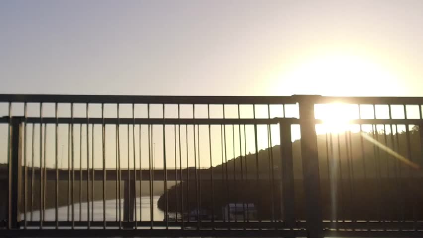 Driving over a bridge as the sun sets.