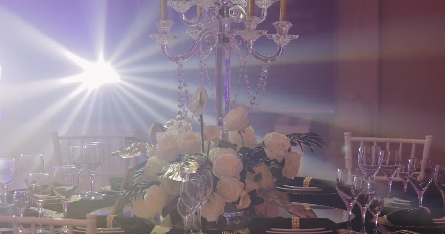 Cutlery on table with a black tablecloth in rays of light from the music scene. The festive dinner in luxury restaurant