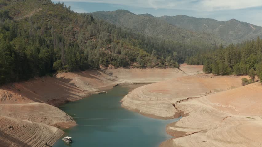 Aerial view of Shasta Lake flying by the water with hills in the background Northern California low water levels during drought Royalty-Free Stock Footage #1026947585
