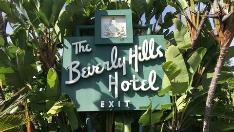 LOS ANGELES, March 30th, 2019: Steady close up shot of the Beverly Hills Hotel sign on Sunset Boulevard on a sunny day, surrounded by palms and a blue sky. The hotel is owned by the Sultan of Brunei.