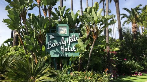 LOS ANGELES, March 30th, 2019: Steady shot of the Beverly Hills Hotel sign on Sunset Boulevard on a sunny day, surrounded by palms and a blue sky. The iconic hotel is owned by the Sultan of Brunei.