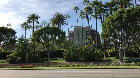 LOS ANGELES, March 30th, 2019: Exterior wide shot of the Beverly Hills Hotel, seen from Sunset Boulevard, with car passing by. The iconic hotel is owned by the Sultan of Brunei.