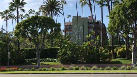 LOS ANGELES, March 30th, 2019: Exterior of the Beverly Hills Hotel on Sunset Boulevard, surrounded by green palms and plants, and a blue sky. The iconic hotel is owned by the Sultan of Brunei.