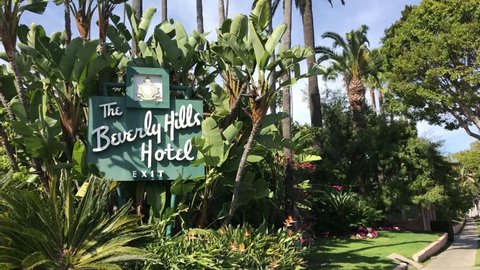 LOS ANGELES, March 30th, 2019: The Beverly Hills Hotel sign, surrounded by green plants, next to the sidewalk on Sunset Boulevard.  The iconic hotel is owned by the Sultan of Brunei.