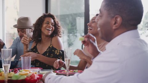 Multi-generation African American family sitting at the dinner table celebrating, low angle close up