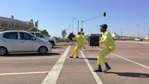 Johannesburg, South Africa, 29th March - 2019: Young men performing at traffic lights with beer bottle crates