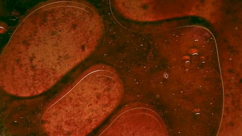 A mysterious red and orange oily liquid swells as blobs and bubbles flow through it. ABSTRACT, HD.