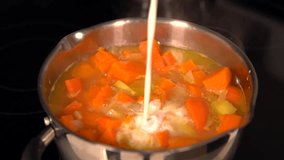Cook adding milk to a pot of boiled vegetables