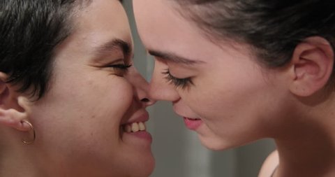 Young latino people and romance with hispanic women, love between lesbians. Homosexual couple, happy girls flirting and lesbian kissing in same sex relationship. Gay woman smiling with happy partner