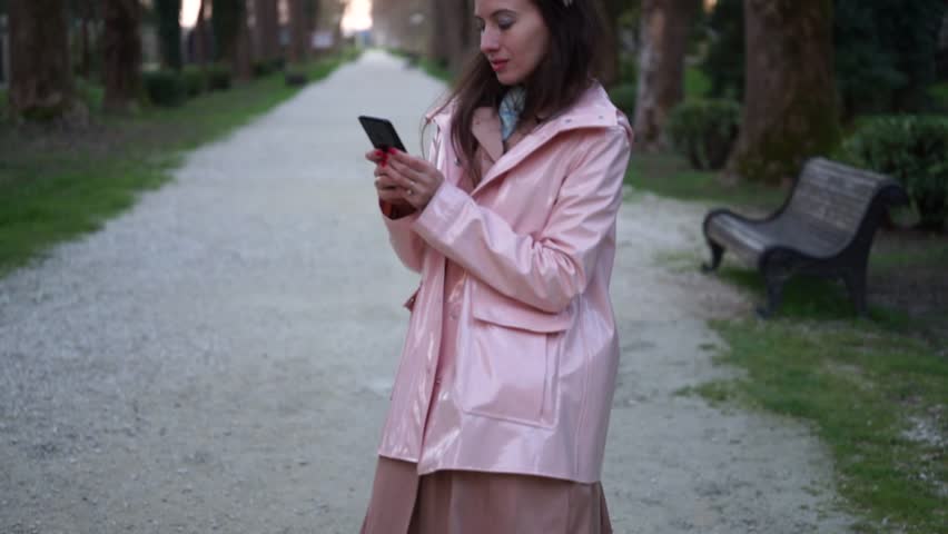 Beautiful vintage woman is chatting on the phone in the park. Concepts outdoor, open air