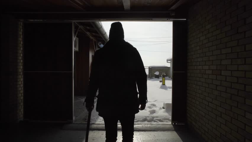 man exiting barn cleaning shovelling fresh snow in yard 
