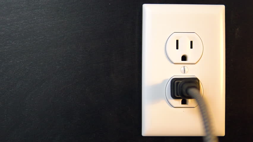 Lights on and off when a two pronged cord connects and disconnects with the bottom outlet of an American electrical socket, Copy Space Left | Shutterstock HD Video #1027002800