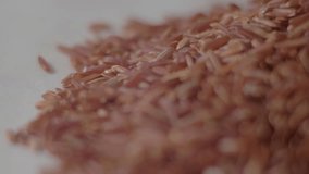Raw red rice on the table. Red rice closeup. Concept: footage for the recipe. 4K. Food video