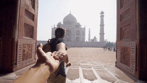 Follow me to concept: young man holding hand of girlfriend leading the way to beautiful temple in India - Personal perspective of girl giving hand to partner traveling together 