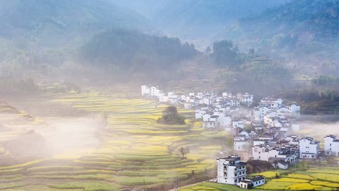 time lapse of wuyuan spring scenery, the mountain village in morning fog,rapeseed flowers bloom in the most beautiful countryside in China.