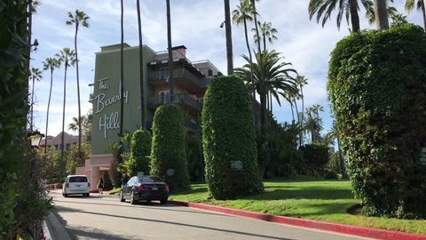 LOS ANGELES, March 30th, 2019: The driveway leading up to the Beverly Hills Hotel, with people walking near the building. The hotel is owned by the sultan of Brunei.