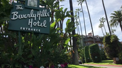 LOS ANGELES, March 30th, 2019: The Beverly Hills Hotel entrance sign next to the driveway leading up to the hotel. The iconic hotel is owned by the Sultan of Brunei.