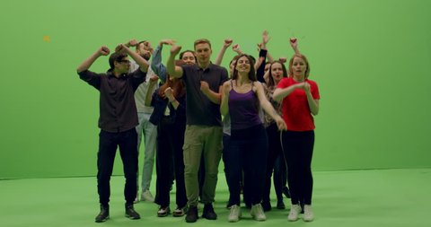 GREEN SCREEN CHROMA KEY Front view group of young people dancing and jumping with hands in the air. 4K UHD ProRes 4444