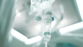 Intravenous drip in focus,surgeons team performing operation in the background,out of focus,infusion dripping. - Powered by Shutterstock - Get 15% off with code: PIKWIZARD15