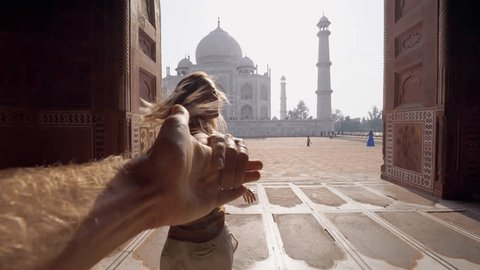 Follow me to the Taj Mahal, India. Female tourist leading boyfriend to there magnificent famous Mausoleum in Agra. People travel concept .leading the way