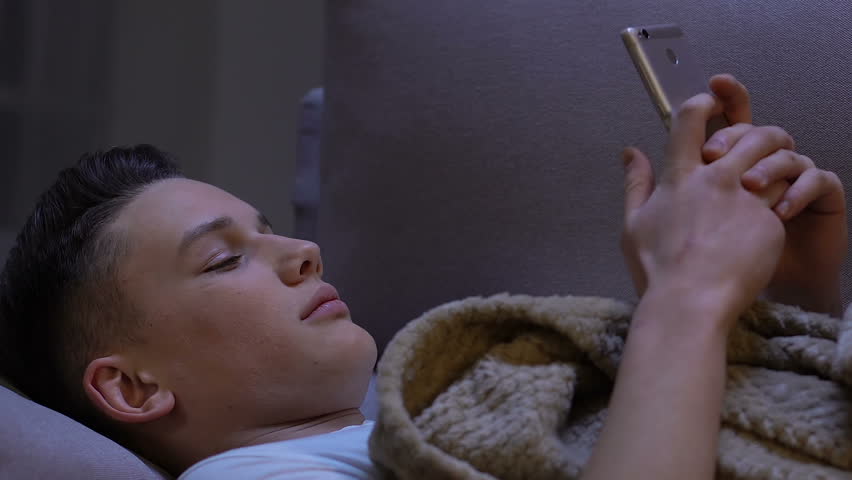Teenager in bed scrolling smartphone, surprised by sales in brand online shop | Shutterstock HD Video #1027058285