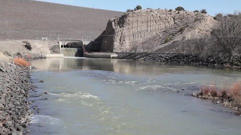 The Rio Grande River emerges from the outlet at Cochiti Dam, just north of Albuquerque, New Mexico, in the early springtime.