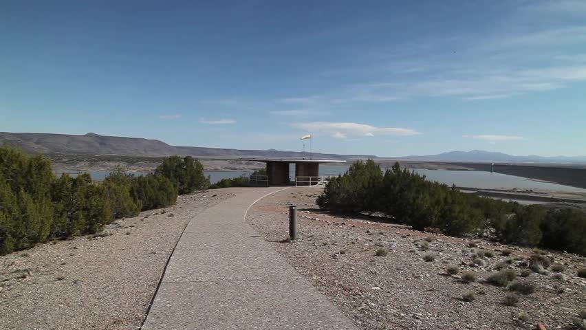 Left to right pan from near the observation deck, across the scene at Cochiti Reservoir and Dam just north of Albuquerque, New Mexico, with the Sandia Mountains showing in the distance.