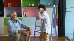 grandfather or senior man and grandson drawing picture art with senior man together with smiling and happy in living room as education concept background