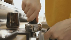 Barista filling up tamper with ground coffee
