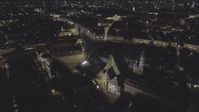 Aerial view of the city of Warsaw. Beautiful view of the old town at night. The royal palace and catholic church is illuminated by lanterns. Drone shot 4k. Video format RAW.