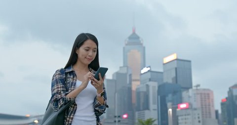 Woman using phone in city